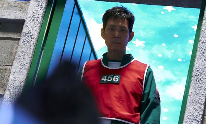 ¿Qué podrás ver en el final del El Juego del Calamar? El sacrificio de Seong Gi-hun, el protagonista, se convierte en el momento más impactante: decide quitarse la vida para que un bebé —último competidor y símbolo de inocencia— gane el juego y reciba el premio millonario. Este acto heroico, lejos de ser un final feliz, refuerza el mensaje central de la serie sobre las consecuencias extremas de la desigualdad y la desesperación. Otro punto clave es el regreso del policía Jun-ho, quien sobrevive y logra rescatar al bebé tras la explosión que destruye la isla. Mientras tanto, In-ho, el antiguo “Front Man” y hermano de Jun-ho, toma una decisión inesperada: hacer estallar el lugar del juego, cerrar el ciclo violento y escapar con el bebé, dejando abierta la duda sobre si actúa como redentor o como alguien con sus propios intereses. La historia da un giro internacional en la última escena, cuando aparece una reclutadora interpretada por Cate Blanchett en Los Ángeles, sugiriendo que los juegos mortales podrían expandirse fuera de Corea. Este detalle deja abierta la posibilidad de nuevas temporadas o spin-offs, ampliando el alcance de la crítica social de la serie. El final no solo resuelve el destino de sus personajes principales, sino que transforma el relato: pasa de una lucha individual por sobrevivir a una reflexión colectiva sobre sacrificio, redención y la perpetuidad de un sistema corrupto. La segunda temporada cierra así con fuerza, dejando preguntas sobre el futuro del juego y sobre quién podrá realmente detenerlo.